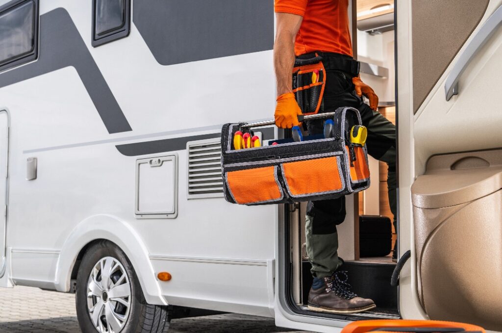 „Wohnmobiltechniker betritt mit Werkzeugkoffer ein Wohnmobil.