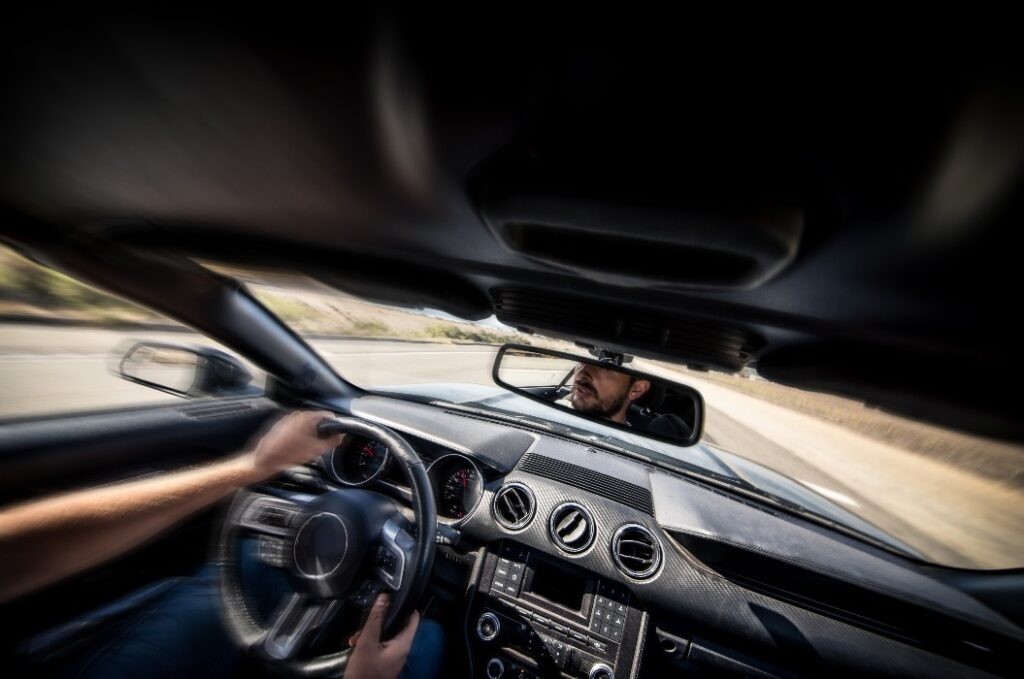 Mann sitzt hinter dem Steuer, während das Auto nach rechts und links zieht.